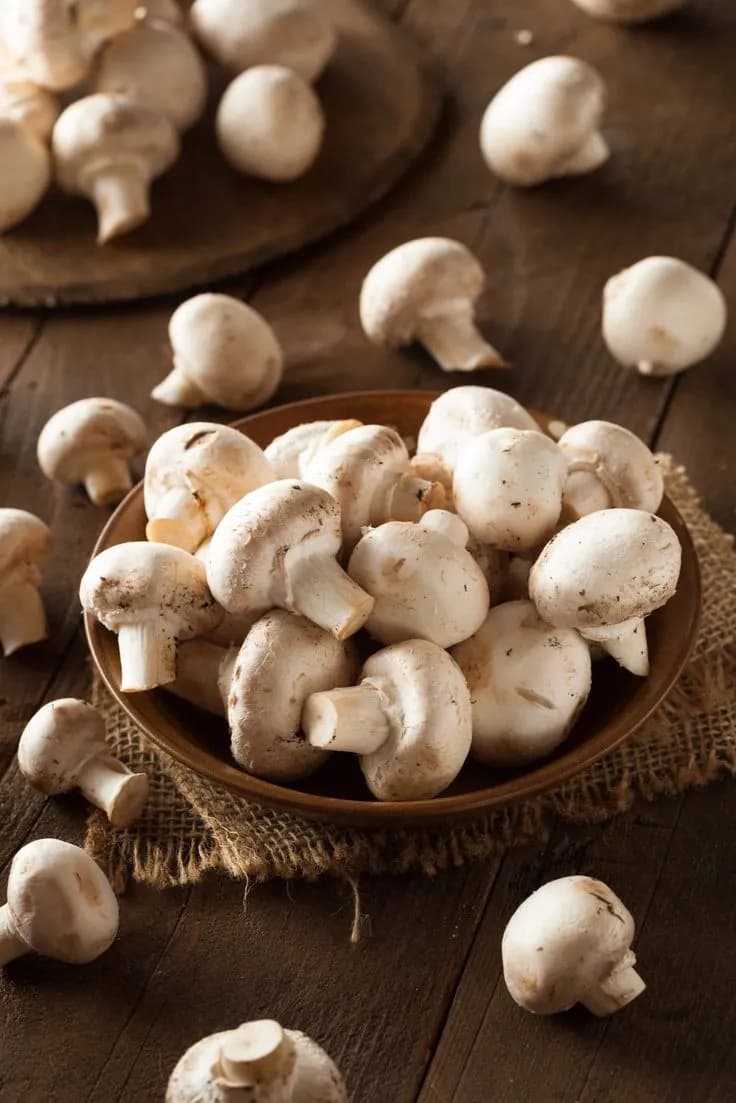 Button mushrooms in a woven basket